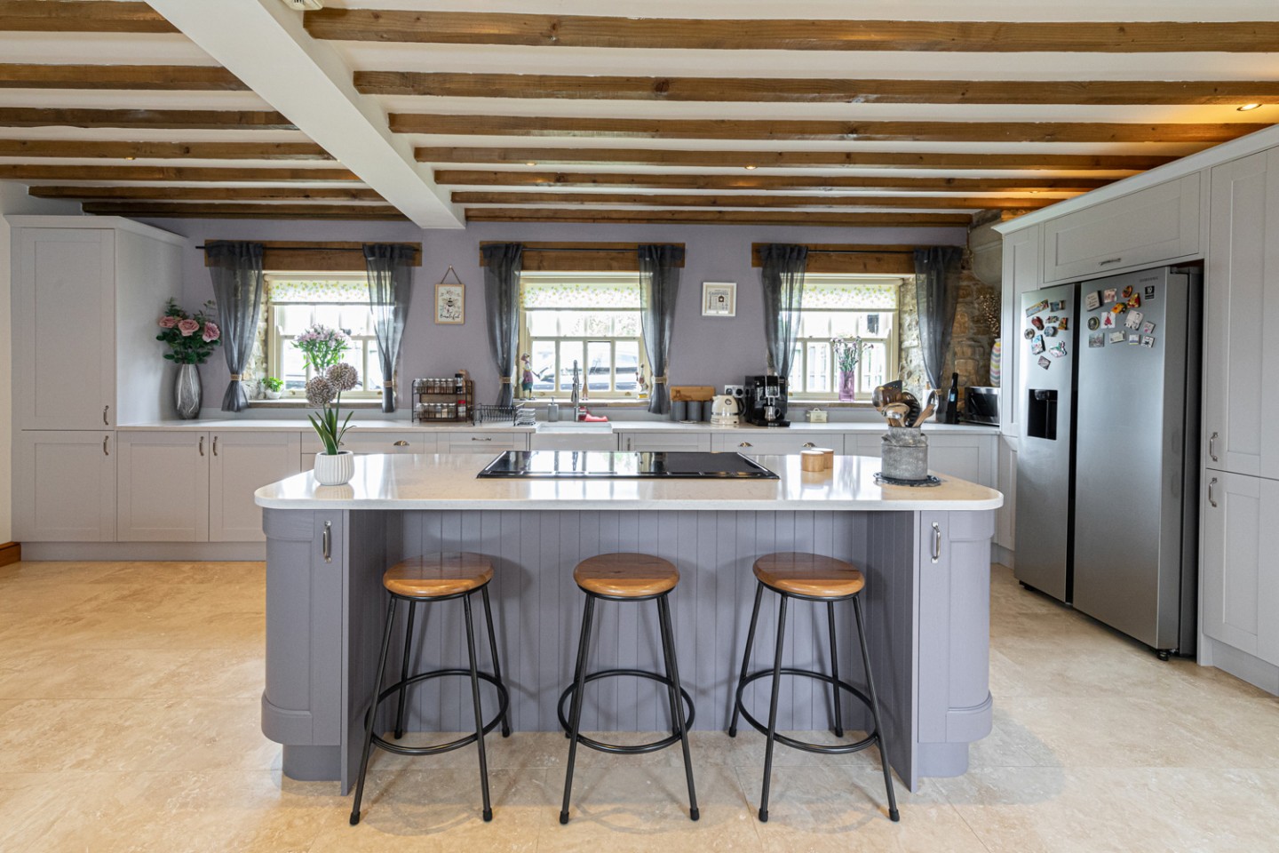 Modern kitchen with lilac island and matching walls, exposed beams